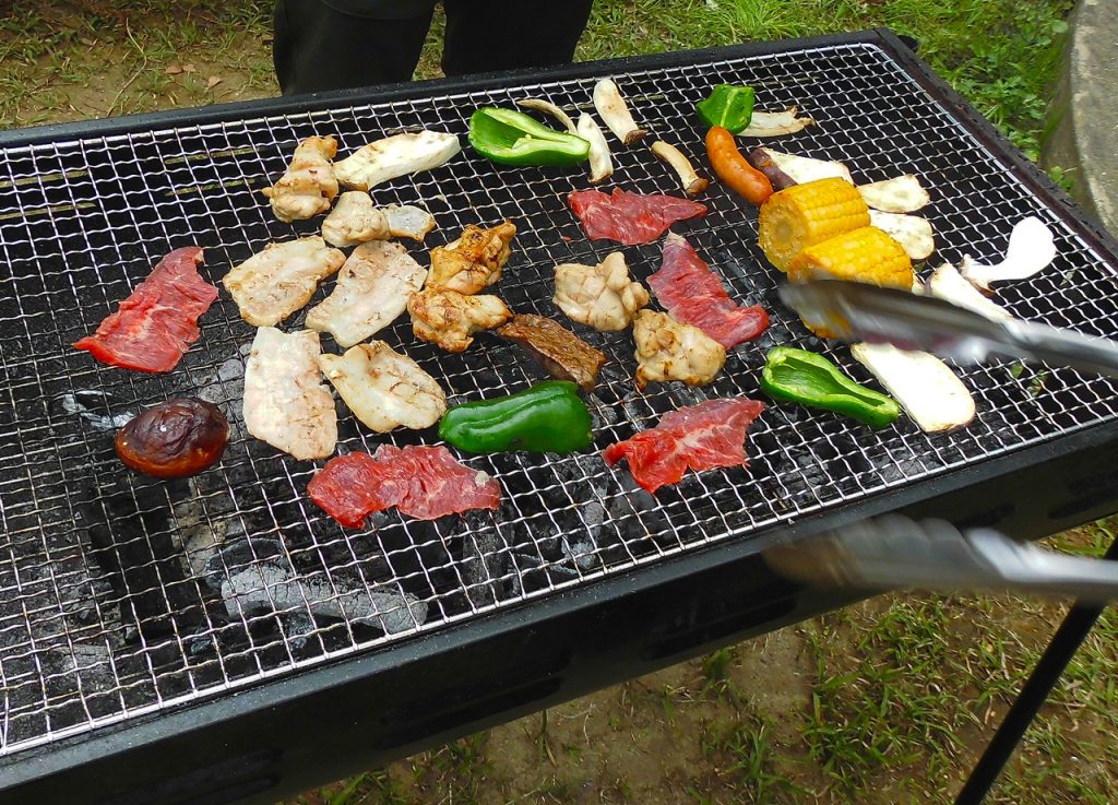 バーベキューで肉と野菜を焼く